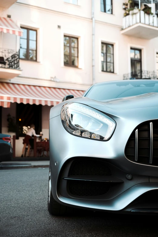 a metallic mercedes car is parked outside of a el