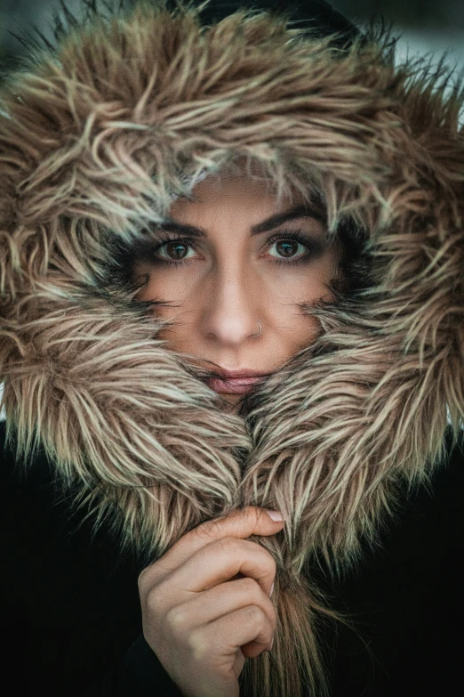 a girl in a fur lined hat poses for a po