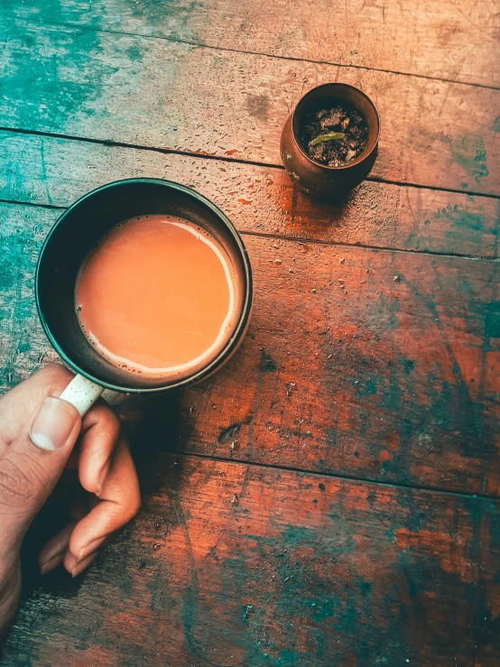 a persons hand holding a cup of coffee