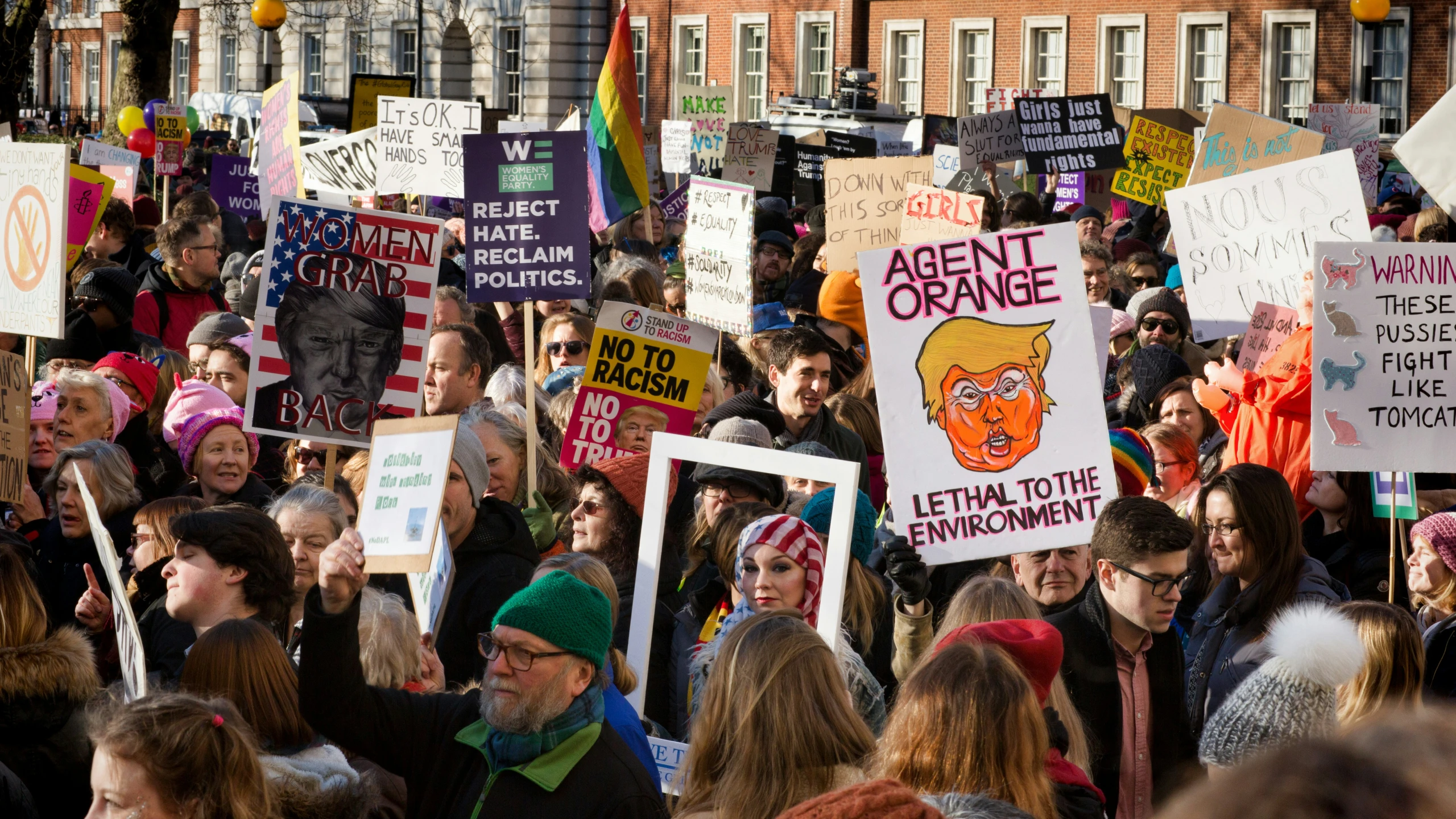 a large group of people holding signs, all holding the same color