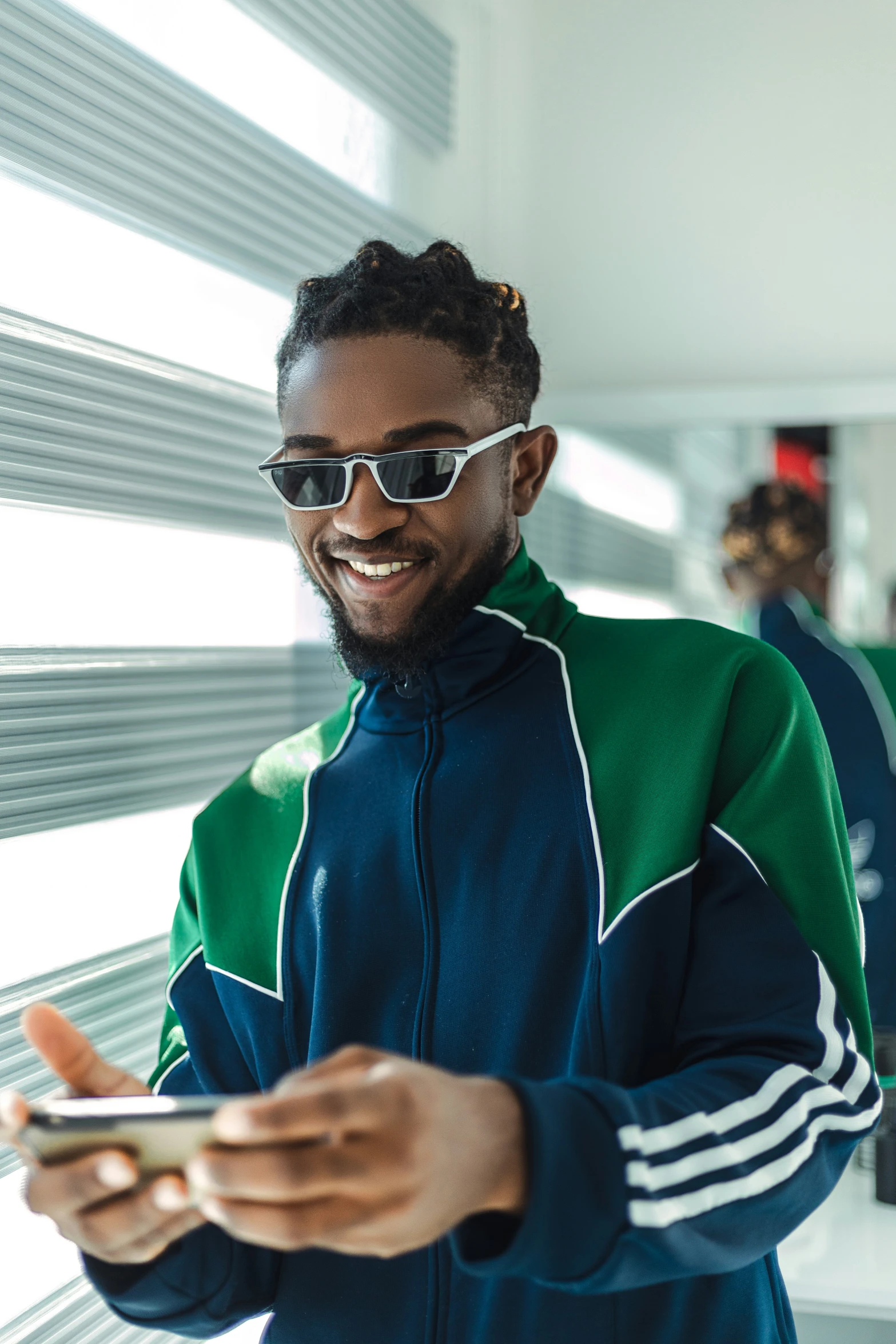 a man wearing sunglasses looks at his cell phone