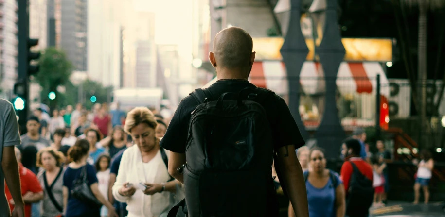 a man and woman standing in front of the camera watching a street full of people