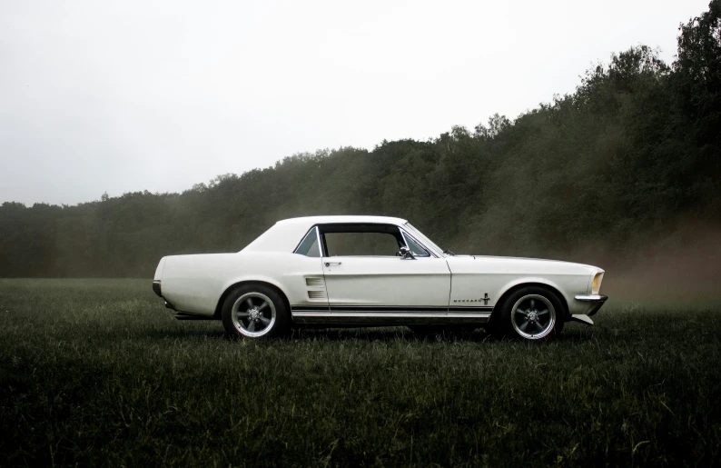 an old model car sits in the middle of a field