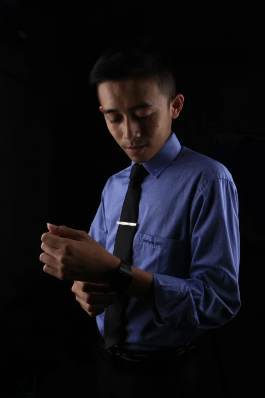 a man in a blue shirt using his smart phone