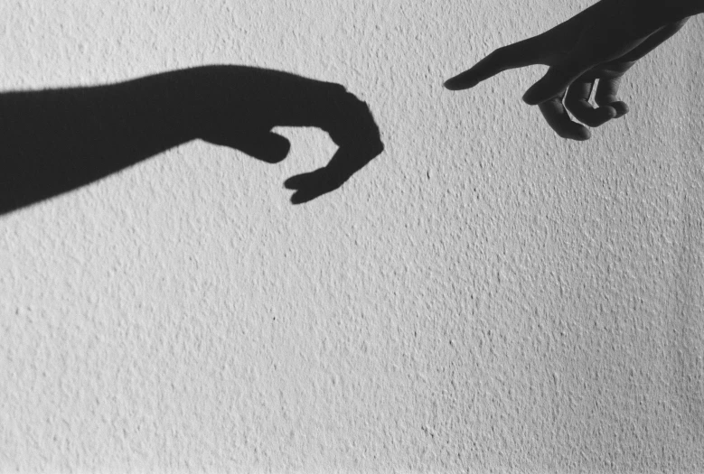 a shadow of two hands on the wall