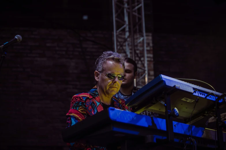 a man with a yellow face paint holding a device at a microphone