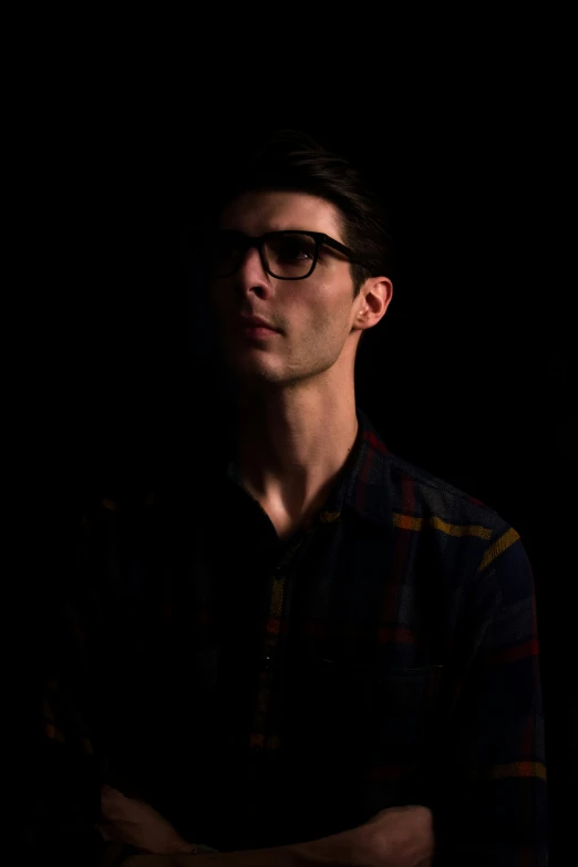 man with dark shirt and glasses looking away