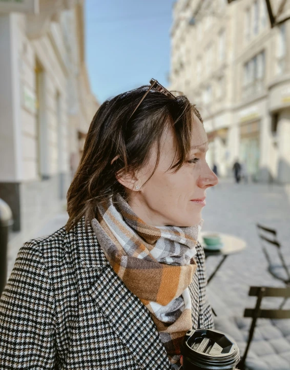 woman with plaid jacket on and scarf around her neck