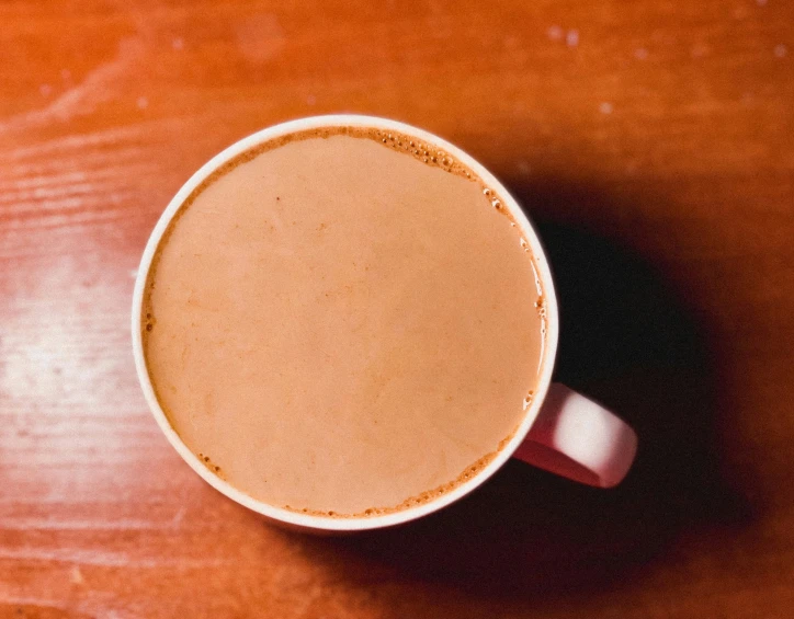 the cup is sitting on top of a wooden table