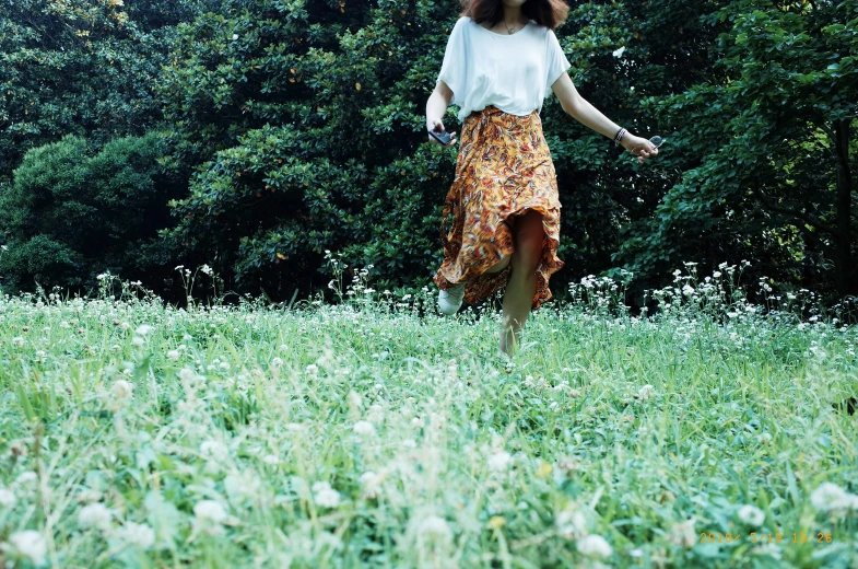 woman in a floral skirt walking through grass