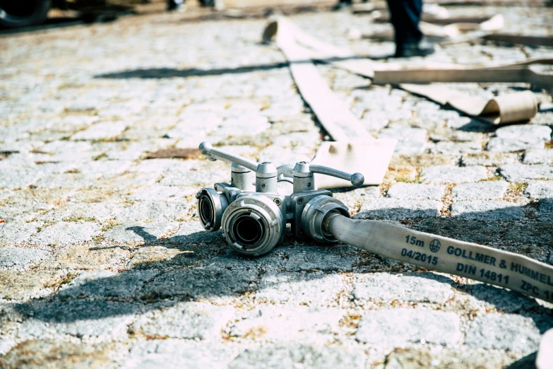 a hose laying on the ground with people walking in the background