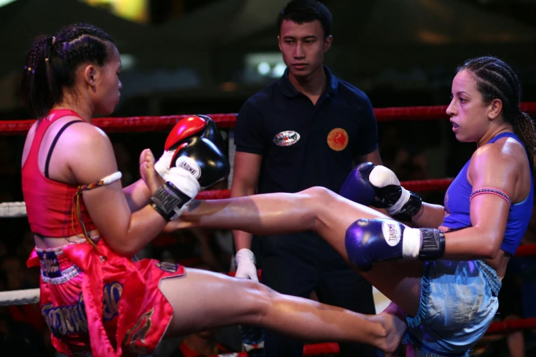 a girl in pink shorts is kicking another girl