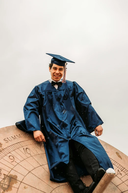 a person wearing a graduation gown is sitting down