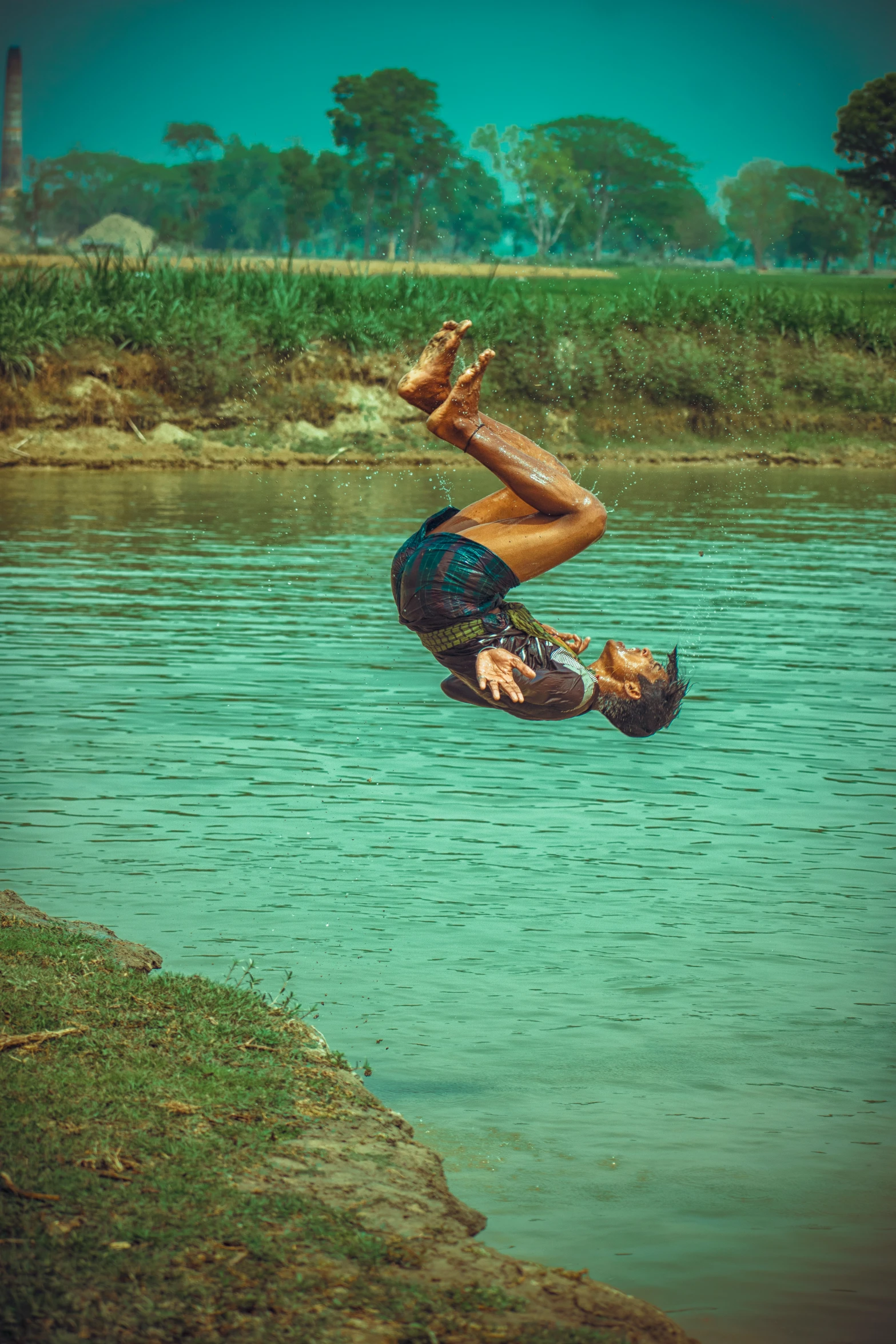 a man jumping in the air into the water