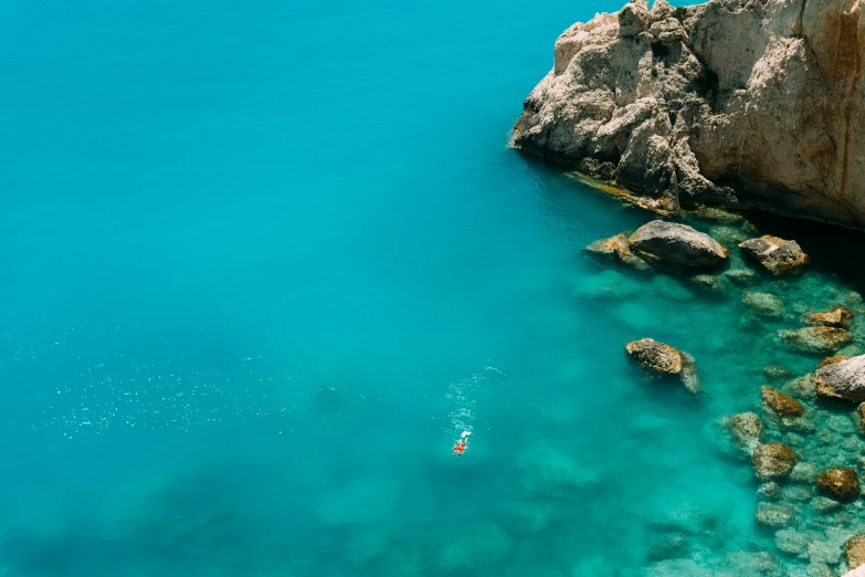 a boat is in the water near rocky shore