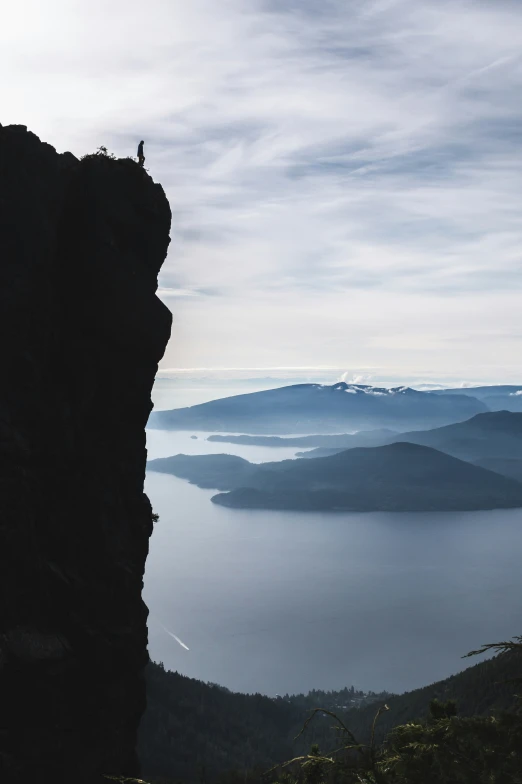 man standing on edge of cliff with ocean and sky in the background