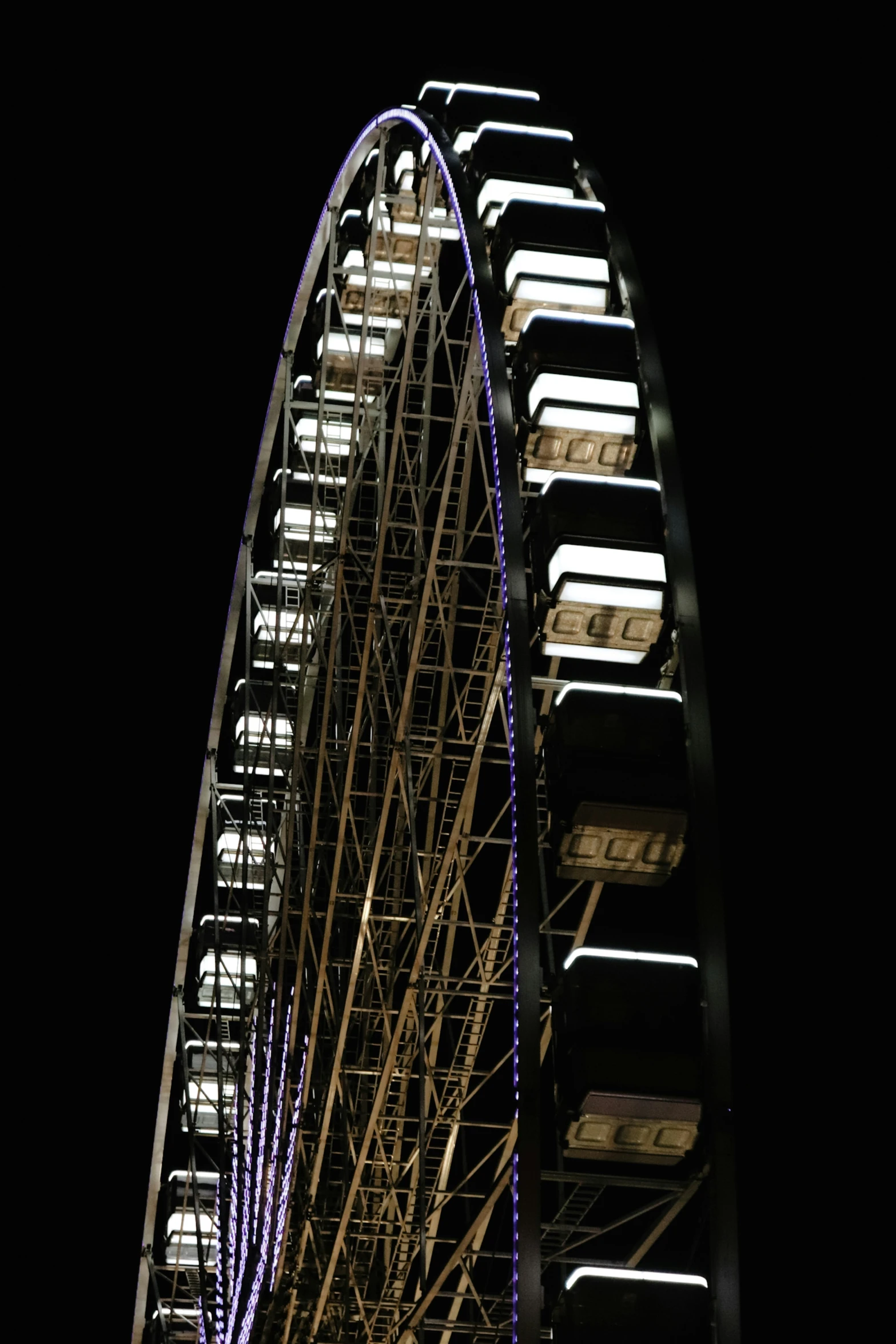 a ferris wheel lit up at night with lights coming out