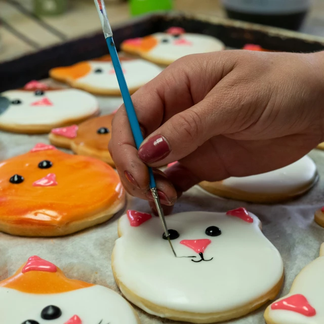 a person is  through decorated cookies with a blue pencil