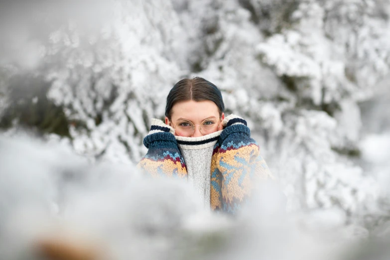 a young woman stands in the snow looking over her shoulder