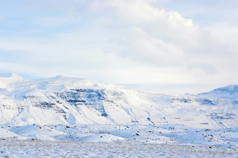 a snowy landscape with mountains in the distance