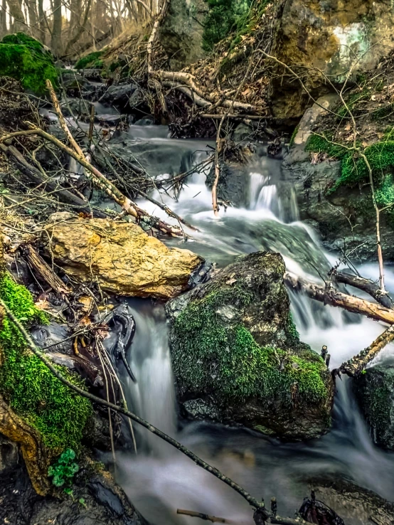 the water is flowing between the rocks in this small creek