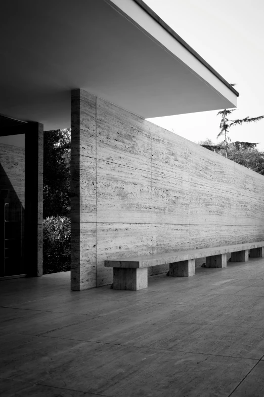 an empty walkway is lined with benches in front of the building