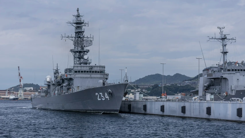 two large ships sit in the water, docked next to each other