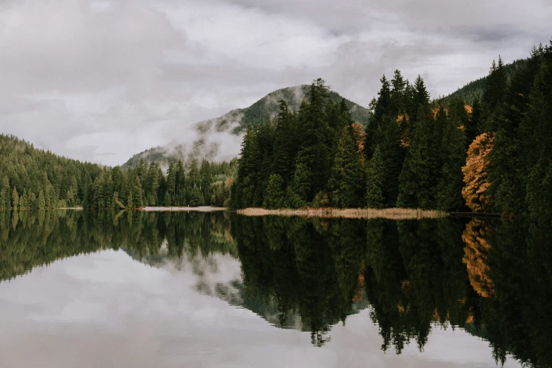 the mountains are reflected in the calm water