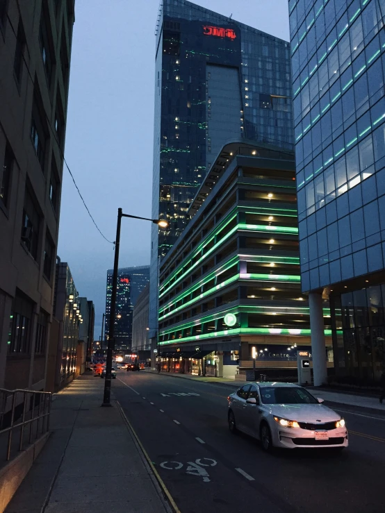 a city street at night with a bunch of buildings on either side of it