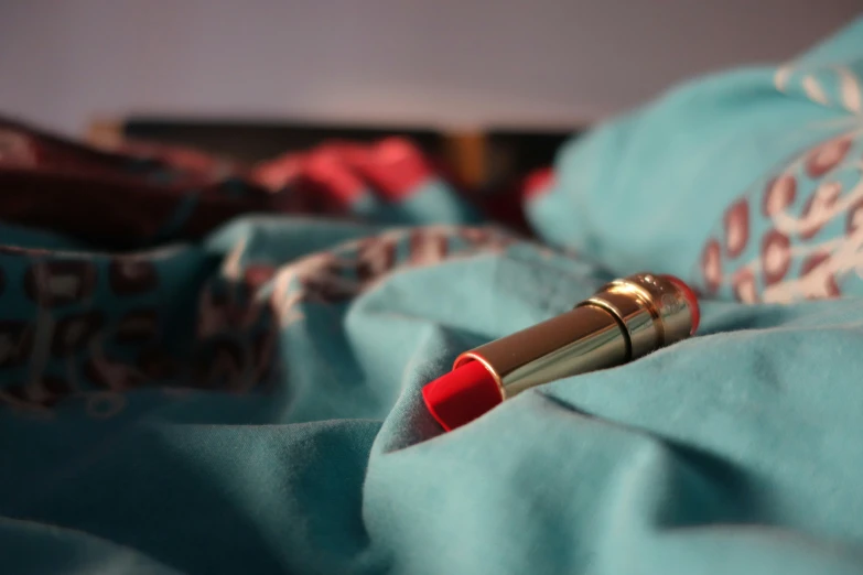 a small red lipstick sticking out of the end of a tube