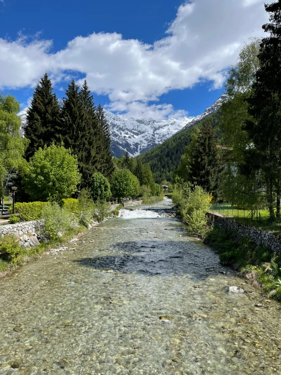 a rocky stream is flowing through a valley