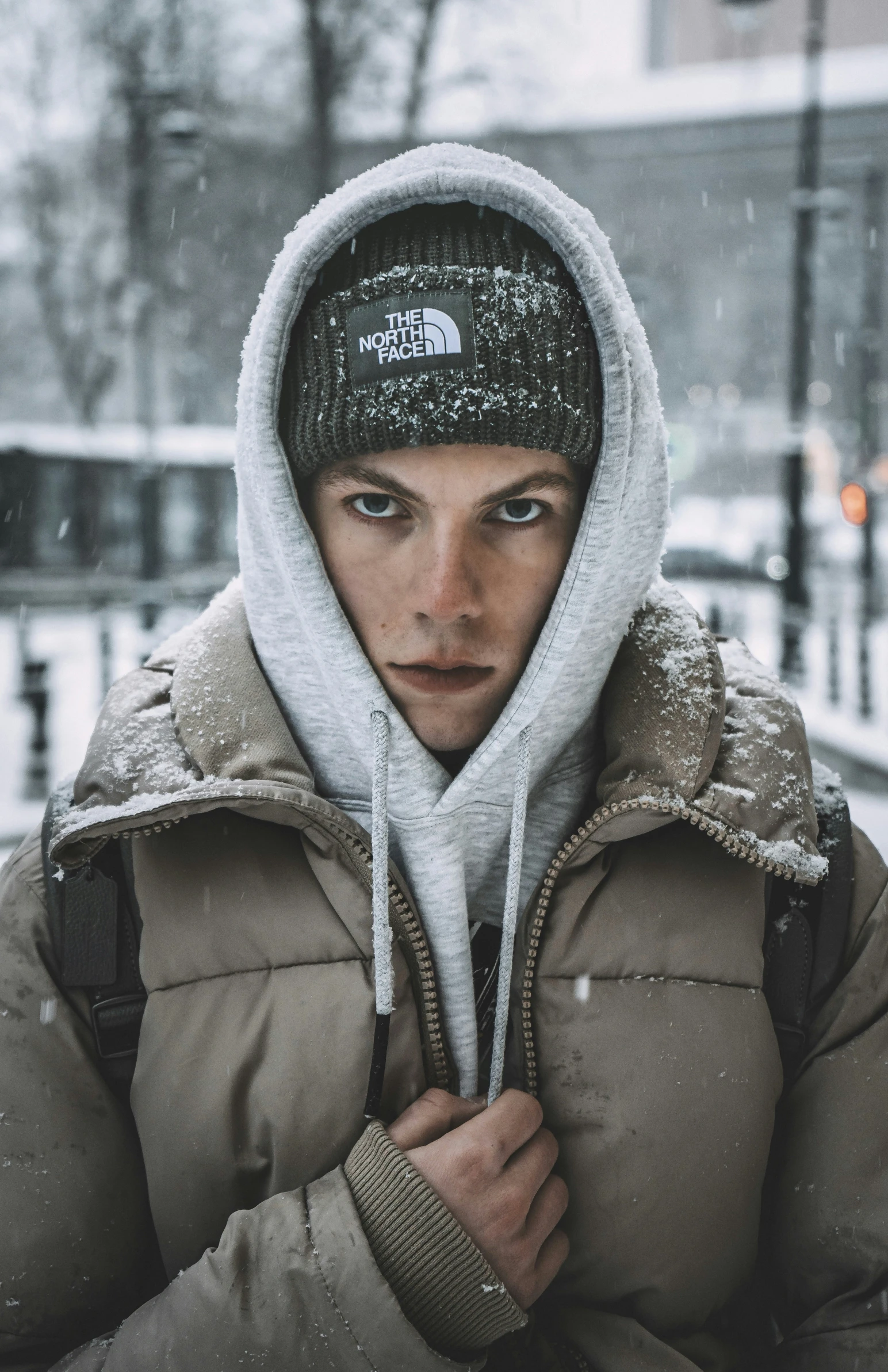 a man wearing winter clothes in front of a snowy street