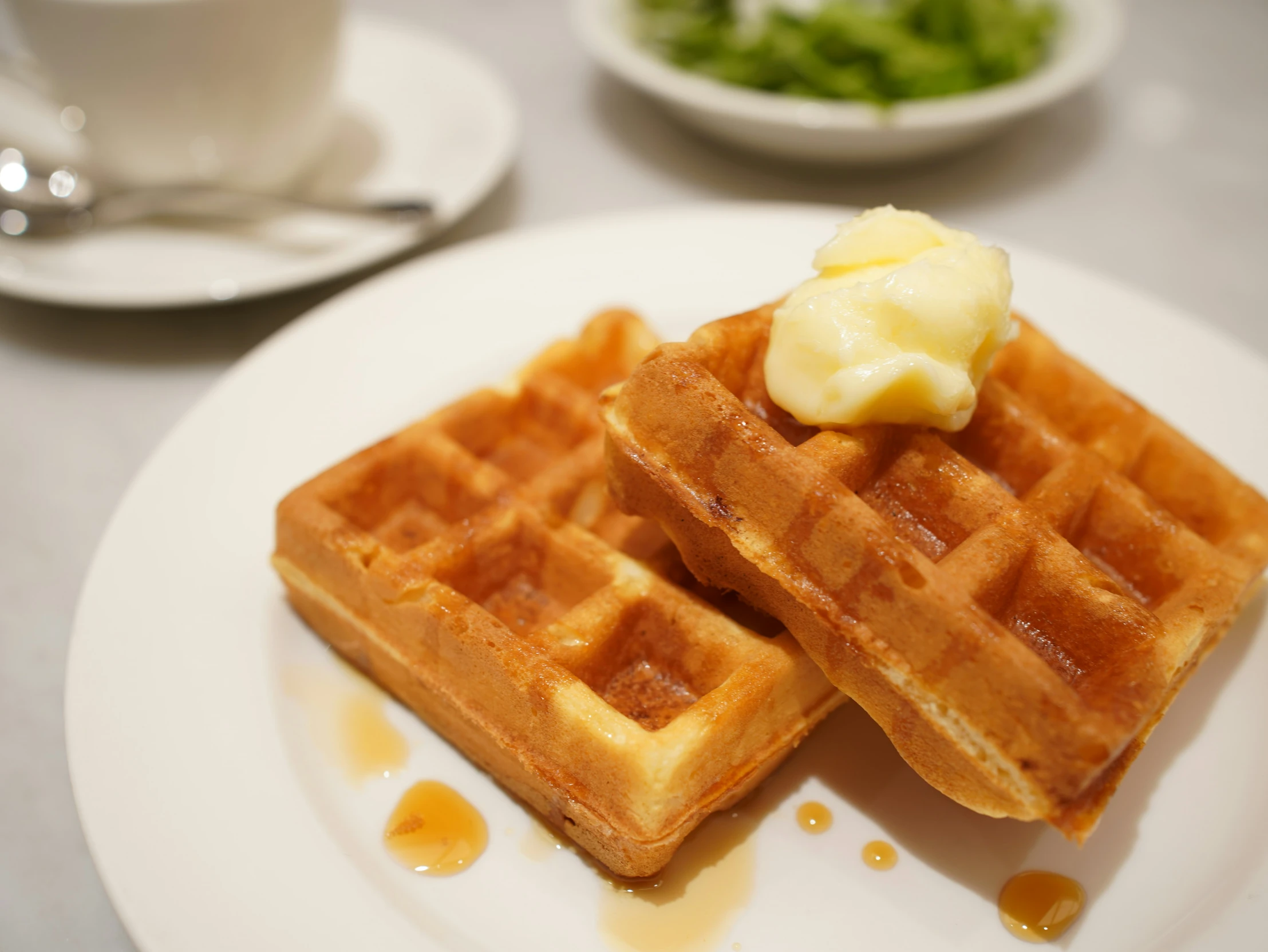 two waffles on a plate with er and syrup