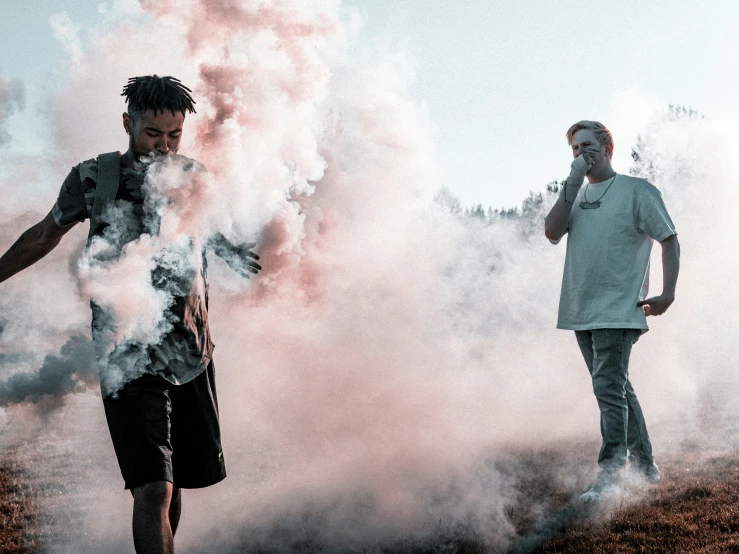 two people walking in smoke while another person has smoke coming from the ground