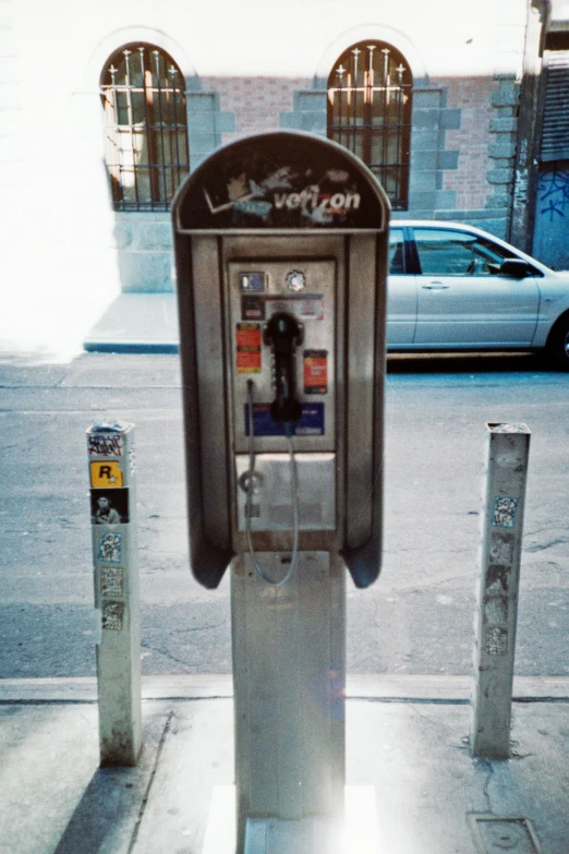 an old, outdated style phone next to a parking meter