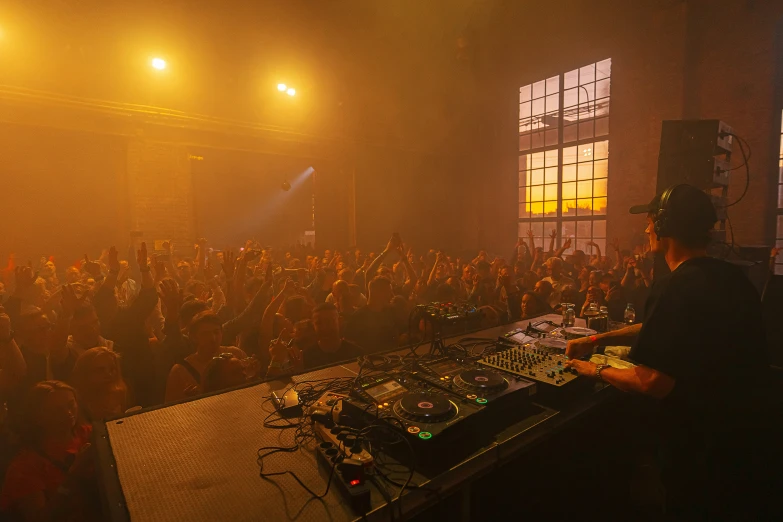 the people are dancing in front of a dj booth