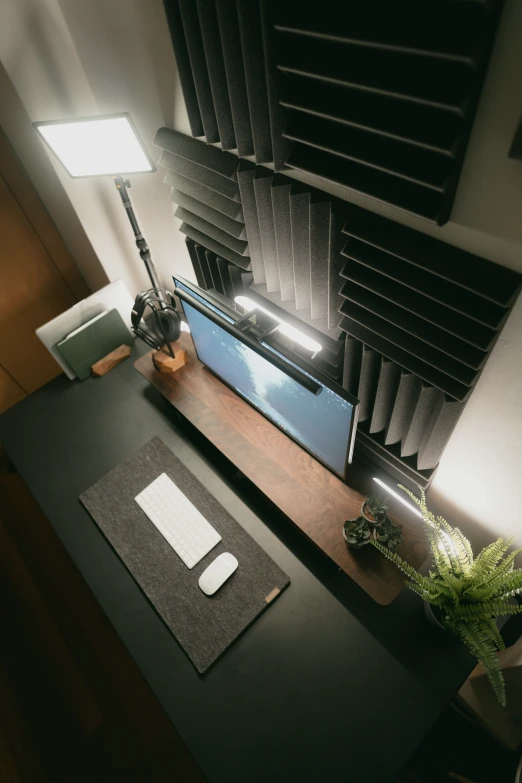 an office desk with a light on and a note pad in front