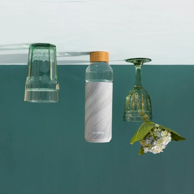 an up close picture of two empty bottles and flowers