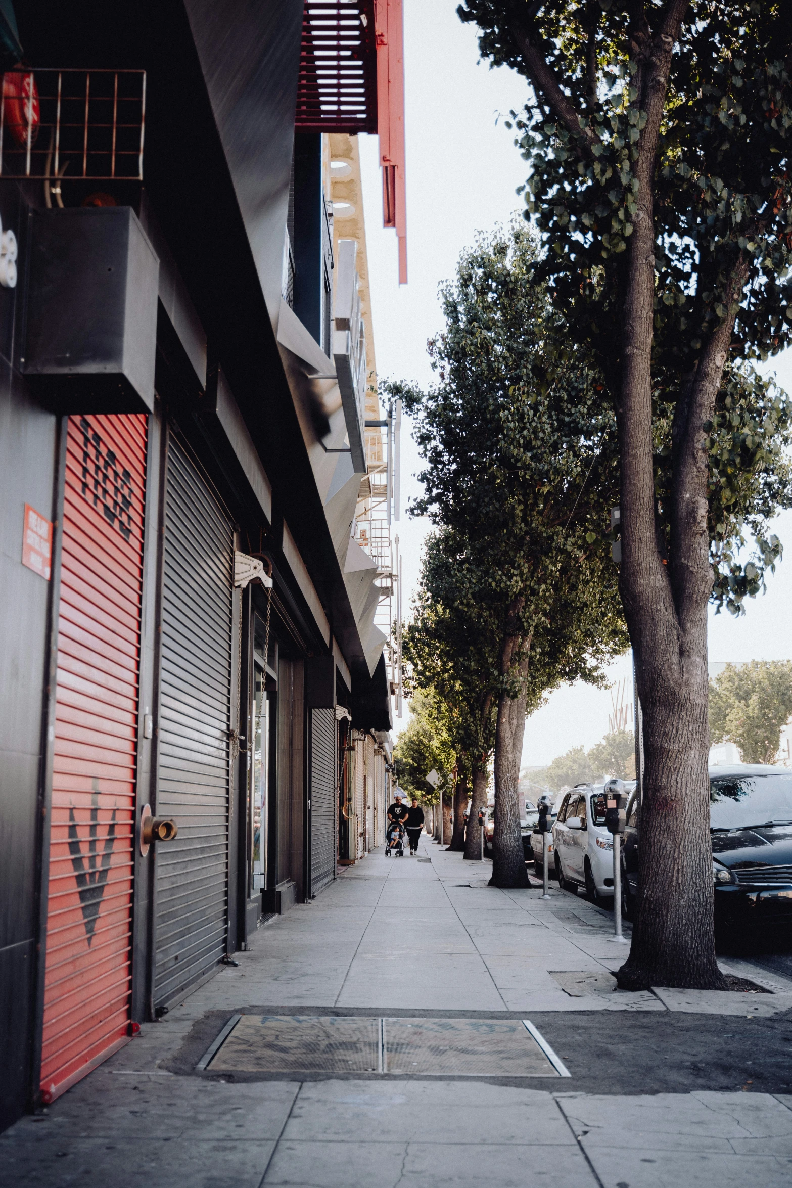 an empty street near parked cars and tall buildings