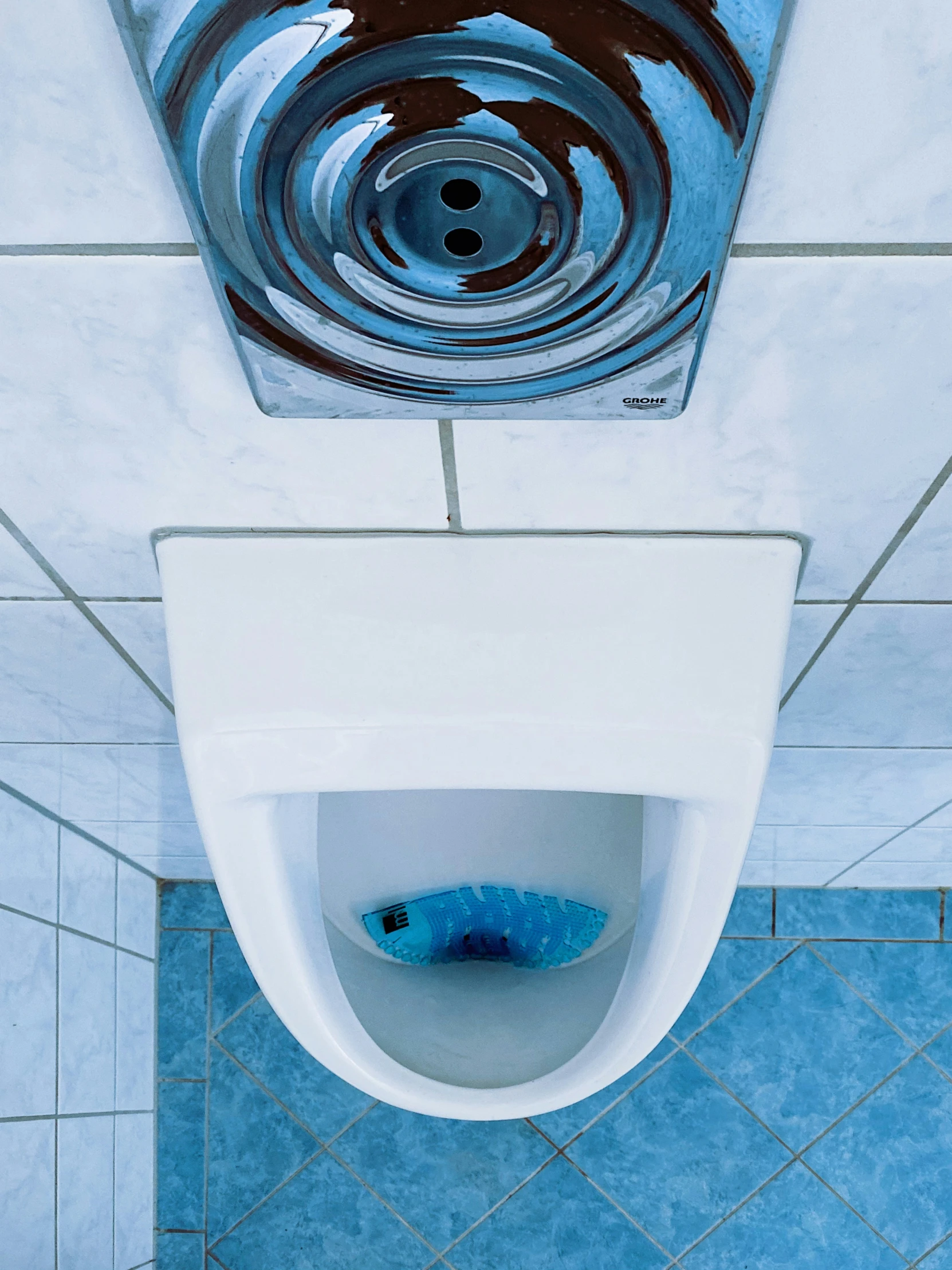 blue and white bathroom with an urinal in the center