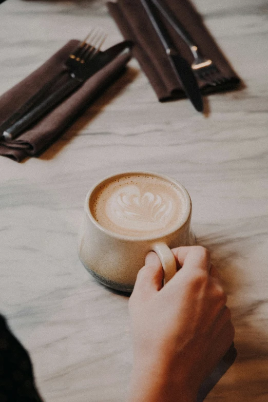 a person is writing on a cup with a pen