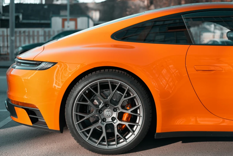 an orange sports car is parked in a parking lot