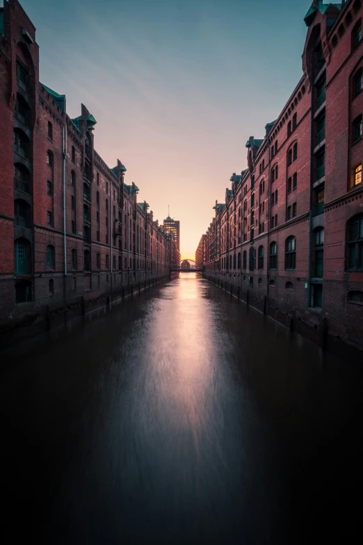 a city is empty with buildings on the side and the sun setting