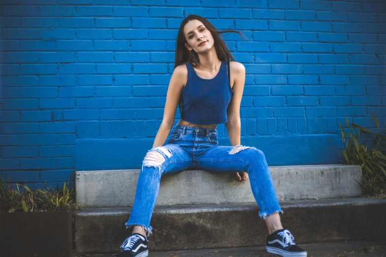 a girl posing on a bench with her legs crossed