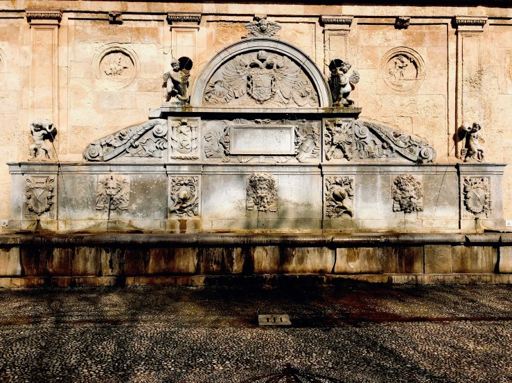 the wall and fountain have carved carvings on it