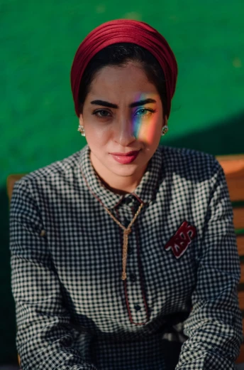 a woman sitting on a bench with rainbow painted on her face
