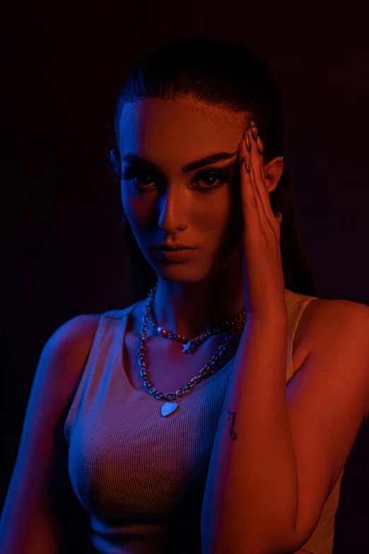 young woman in white shirt holding her hand to the ear with a dark background