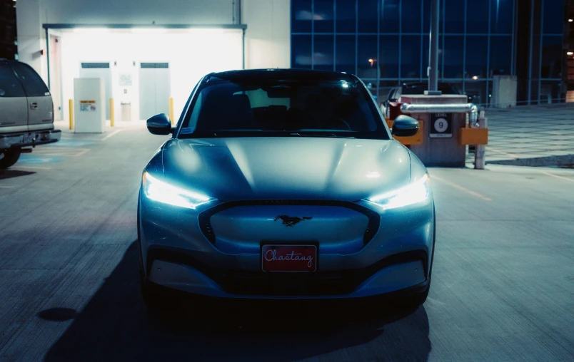 an electric car sitting in a parking lot next to another car