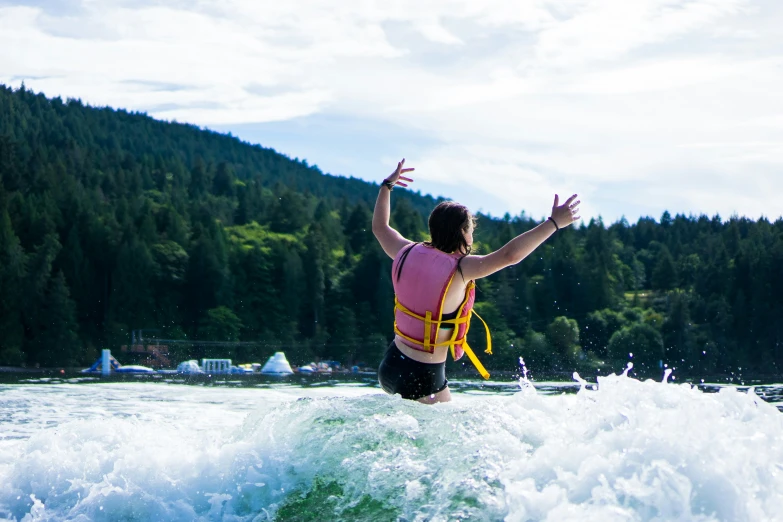 a man with a life jacket standing on a wave in a river