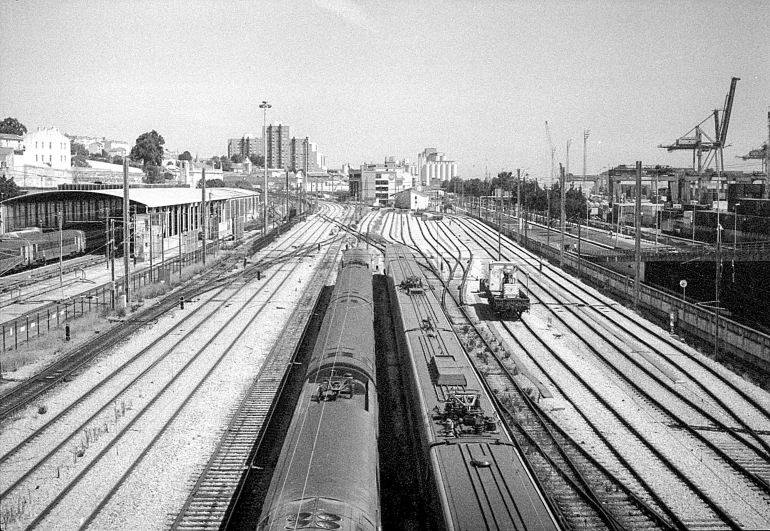 a black and white picture of train tracks in a town